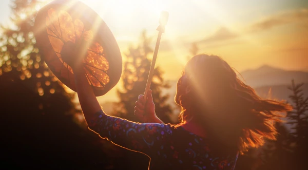 femme qui joue au tambour coucher du soleil