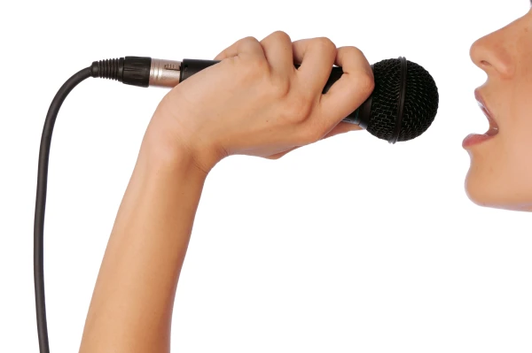 fond blanc une partie de visage d'une femme bouche ouverte qui porte un microphone