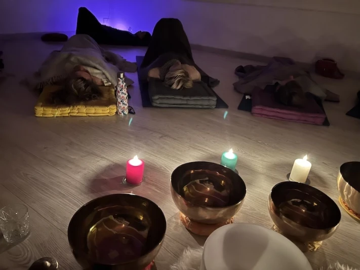bols tibetains et bougies pendant un voyage sonore avec les gens allongés et une lumière douce
