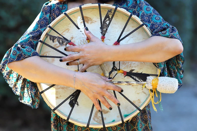 Femme tenant un tambour chamanique entre ses bras